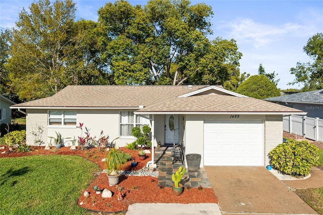 ranch-style house featuring concrete driveway, a shingled roof, a garage, and fence