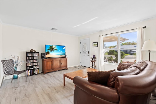 living room with visible vents, ornamental molding, light wood finished floors, and baseboards