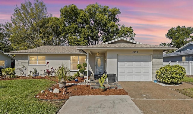 single story home with a garage, stucco siding, driveway, and fence
