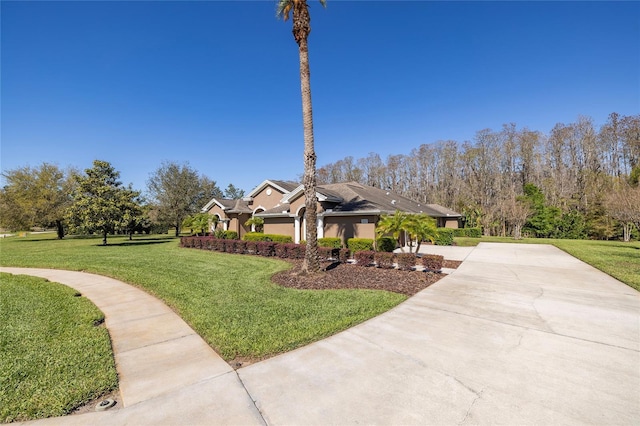 exterior space featuring stucco siding, driveway, and a front lawn