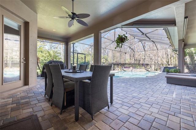 view of patio featuring an outdoor pool, glass enclosure, outdoor dining area, and ceiling fan