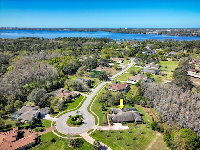 aerial view featuring a wooded view and a water view