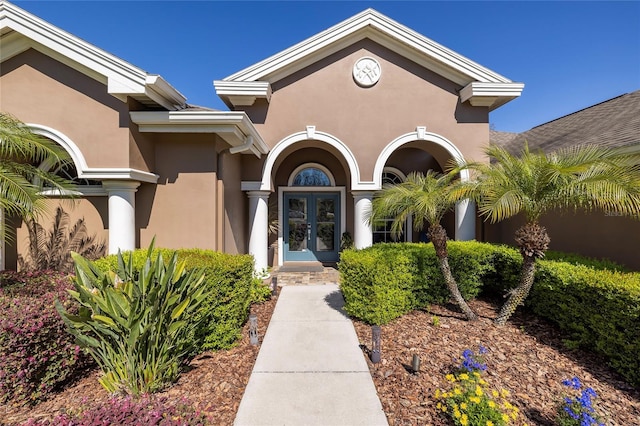 doorway to property featuring french doors and stucco siding