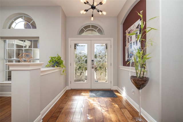 doorway to outside featuring hardwood / wood-style floors, an inviting chandelier, french doors, and baseboards