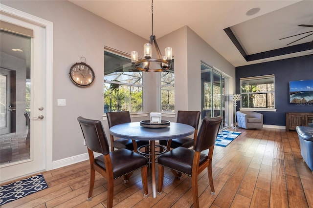 dining space featuring a notable chandelier, baseboards, and wood finished floors