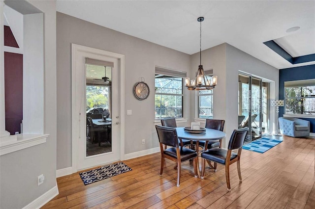 dining space featuring light wood-type flooring, baseboards, and a chandelier