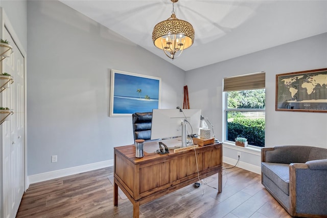 office featuring baseboards, a notable chandelier, wood finished floors, and vaulted ceiling