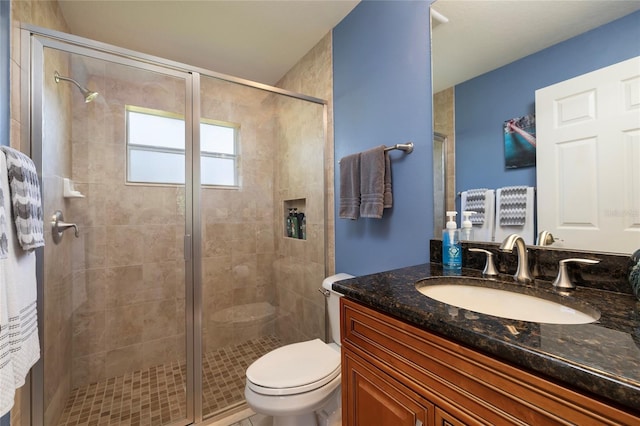 bathroom featuring vanity, toilet, and a stall shower