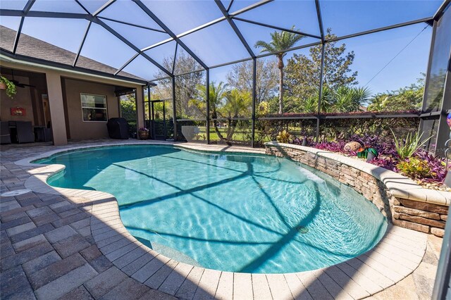 outdoor pool featuring glass enclosure and a patio