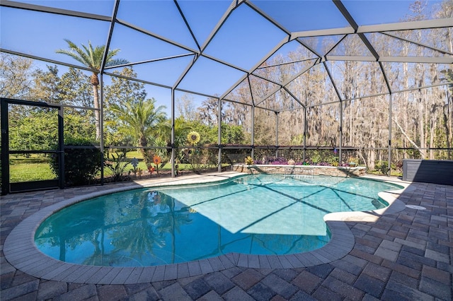 outdoor pool featuring glass enclosure and a patio