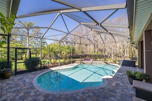 pool featuring glass enclosure and a patio area