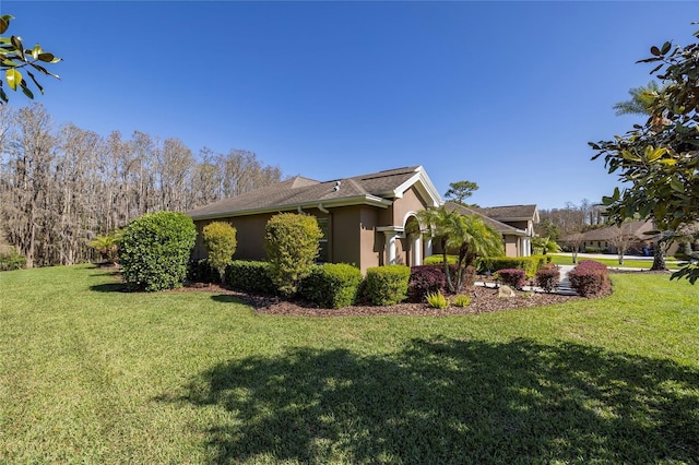 view of property exterior featuring stucco siding and a lawn