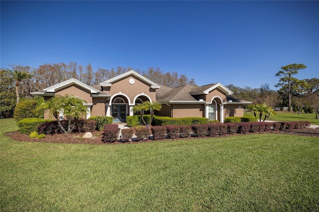 mediterranean / spanish home featuring stucco siding and a front yard