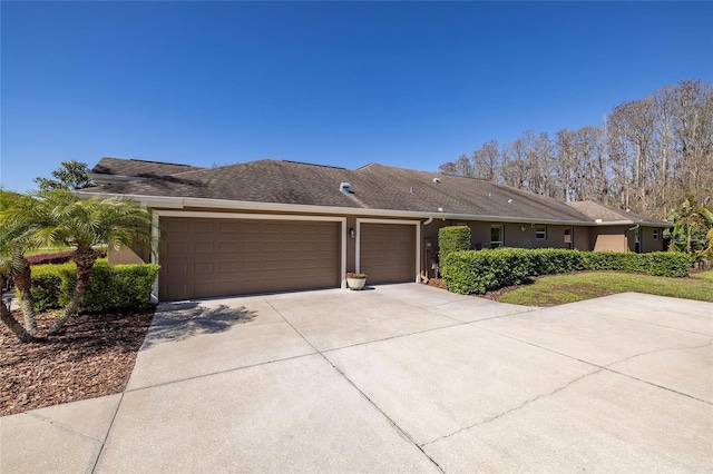 ranch-style home featuring stucco siding, concrete driveway, and an attached garage