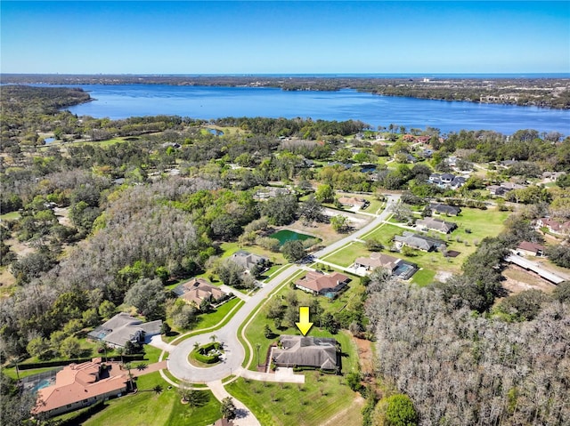 drone / aerial view featuring a wooded view and a water view