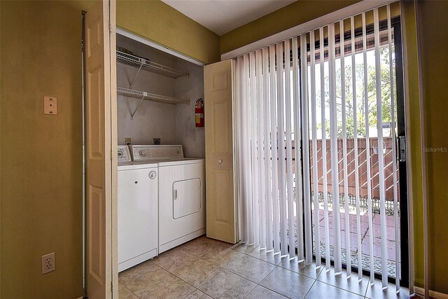 washroom featuring light tile patterned floors, laundry area, and washing machine and dryer