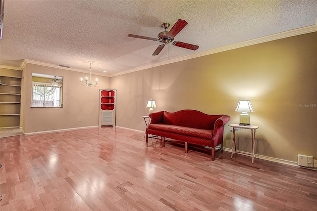 living area with ceiling fan with notable chandelier, crown molding, wood finished floors, and a textured ceiling