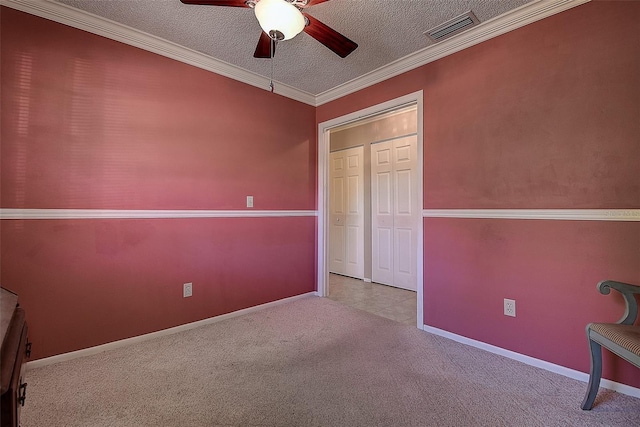 unfurnished bedroom with visible vents, a textured ceiling, carpet, and ornamental molding