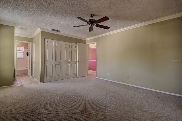 unfurnished bedroom featuring crown molding, carpet flooring, visible vents, and a textured ceiling