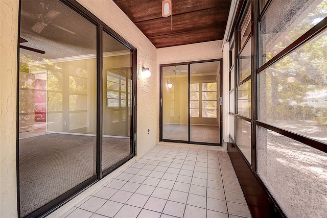 unfurnished sunroom with wooden ceiling and ceiling fan