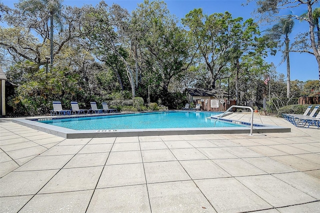 community pool with fence and a patio area