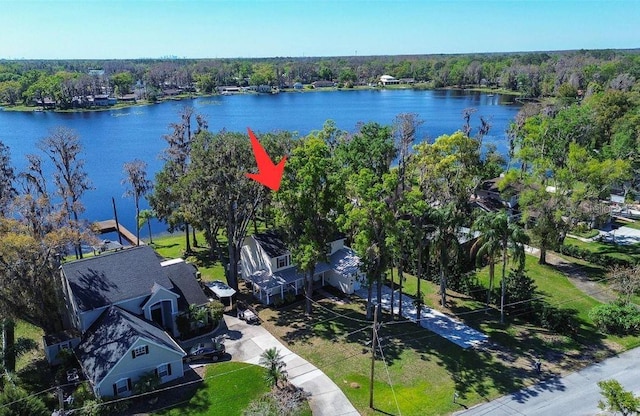 birds eye view of property featuring a water view and a wooded view