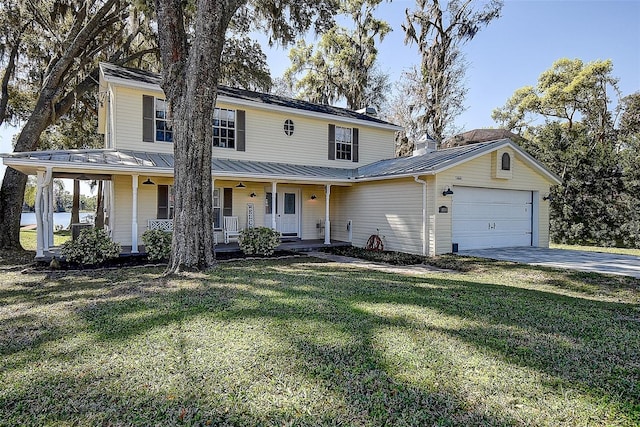 view of front facade with a standing seam roof, covered porch, a front yard, an attached garage, and metal roof