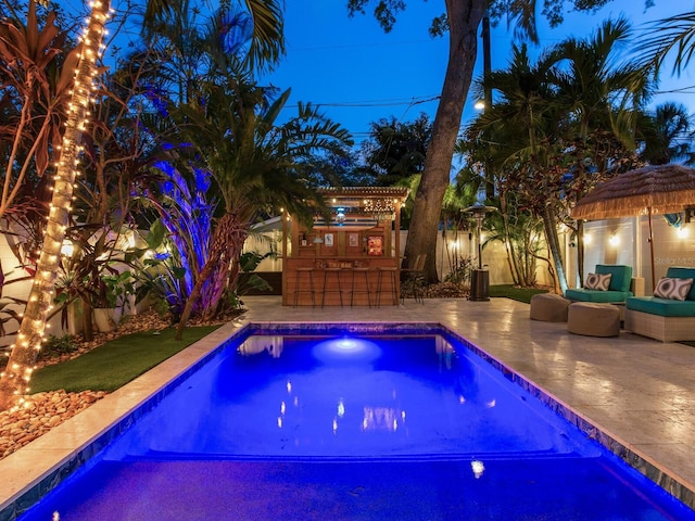 pool featuring outdoor dry bar, a patio area, outdoor lounge area, and a fenced backyard