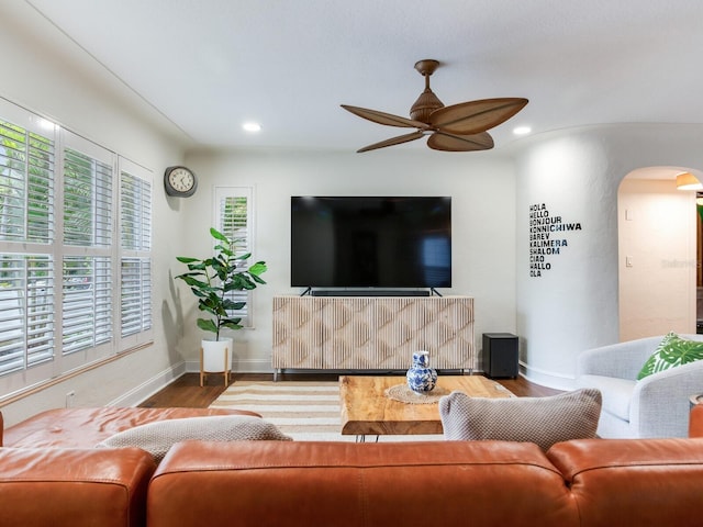 living room featuring a ceiling fan, wood finished floors, recessed lighting, arched walkways, and baseboards