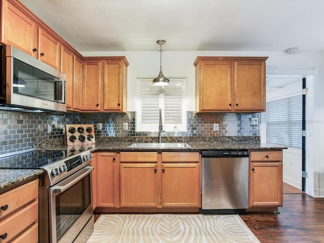 kitchen with a sink, stainless steel appliances, tasteful backsplash, and dark wood-style flooring