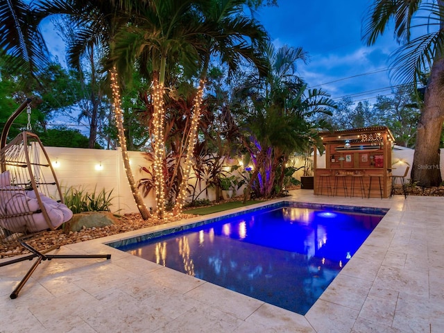 view of swimming pool featuring a fenced backyard, a patio, a fenced in pool, and outdoor dry bar