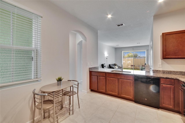 kitchen featuring light stone countertops, visible vents, arched walkways, a sink, and black dishwasher