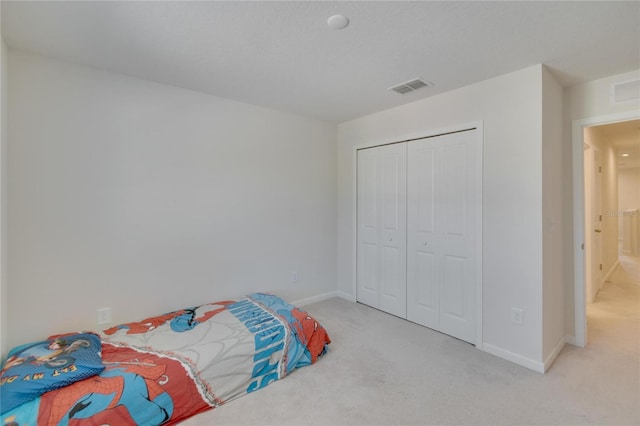 bedroom featuring carpet, visible vents, a closet, and baseboards