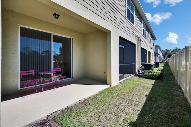 view of yard featuring central AC unit, fence, and a patio