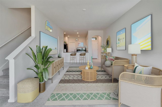 living room with arched walkways, carpet, and stairs