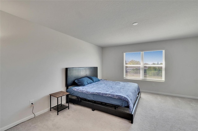 bedroom featuring a textured ceiling, baseboards, and carpet floors