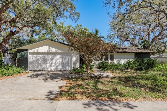 view of front of home featuring a garage, concrete driveway, and stucco siding