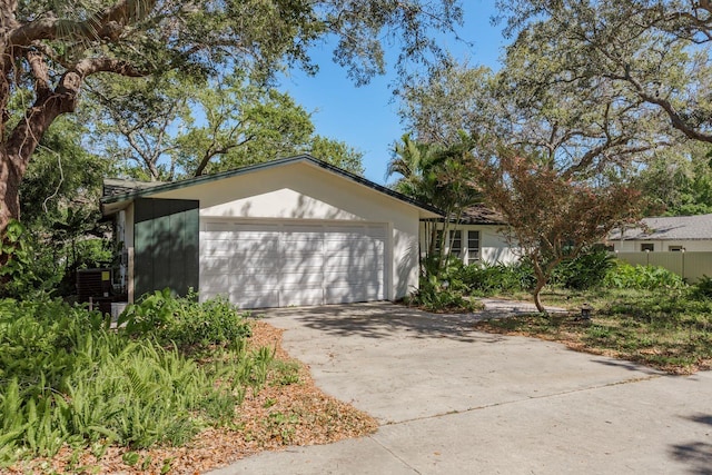 exterior space with concrete driveway, an attached garage, and stucco siding