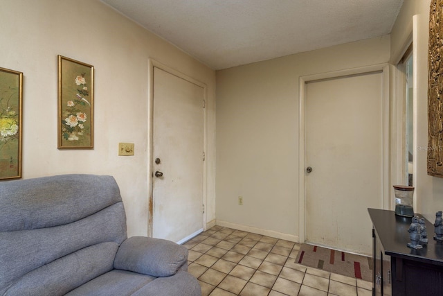 entrance foyer featuring light tile patterned floors, baseboards, and a textured ceiling