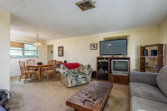 carpeted living area featuring a chandelier and visible vents