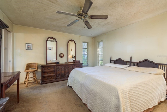 bedroom with a textured ceiling, carpet, and a ceiling fan