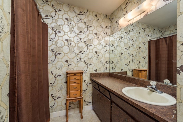 full bathroom featuring tile patterned floors, wallpapered walls, vanity, and baseboards