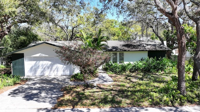 ranch-style home with concrete driveway, an attached garage, and stucco siding