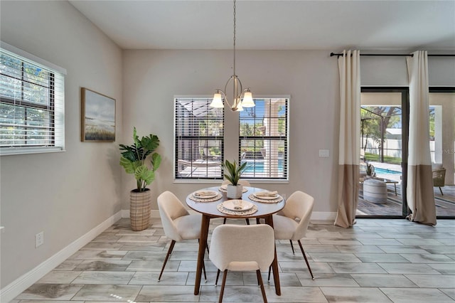 dining room featuring baseboards, a wealth of natural light, and a chandelier