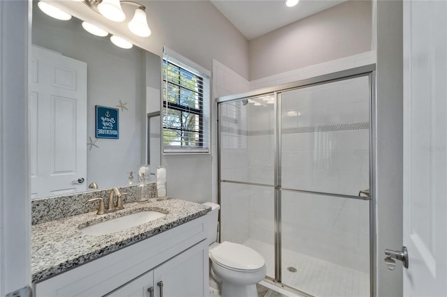 full bath featuring vanity, a shower stall, and toilet