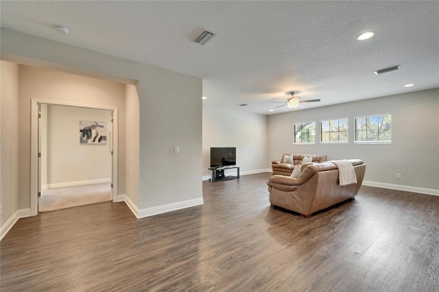 living room featuring visible vents, baseboards, and dark wood-style floors