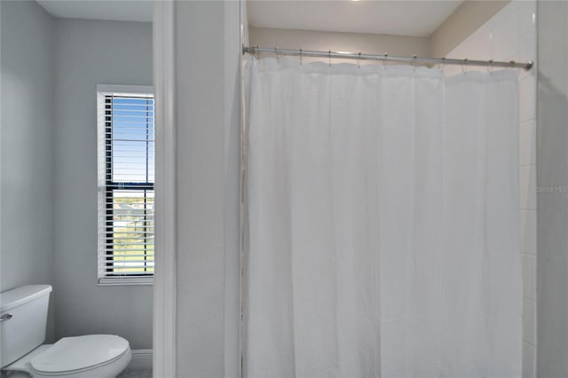 full bathroom with a shower with shower curtain and toilet