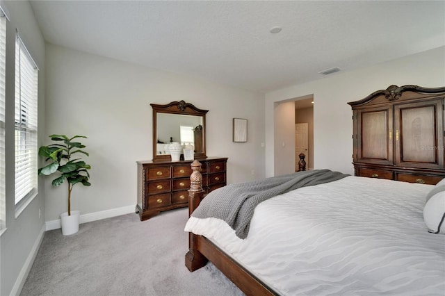 bedroom featuring visible vents, baseboards, and light colored carpet