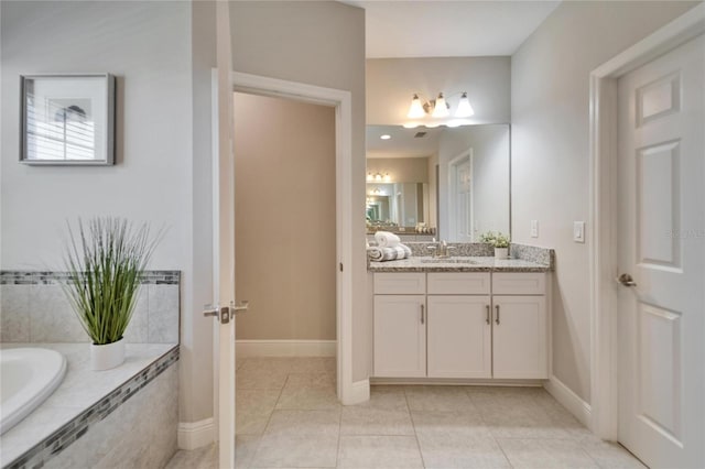 full bathroom featuring a relaxing tiled tub, baseboards, vanity, and tile patterned flooring