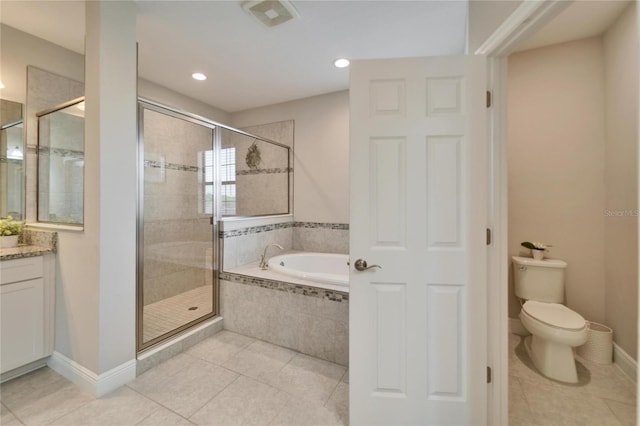 bathroom featuring tile patterned flooring, a shower stall, toilet, a garden tub, and vanity